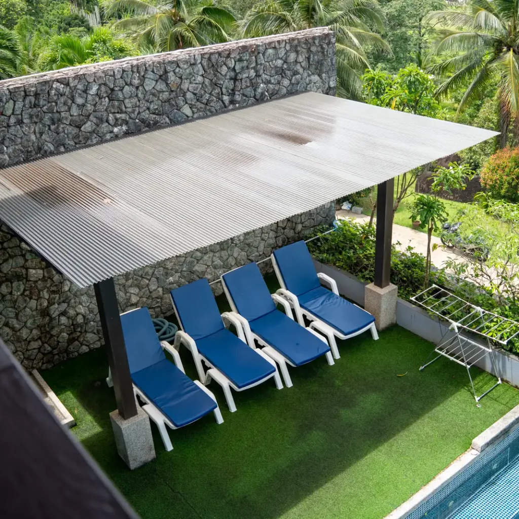 Sun loungers under a pergola by the pool at the Khao Lak villa